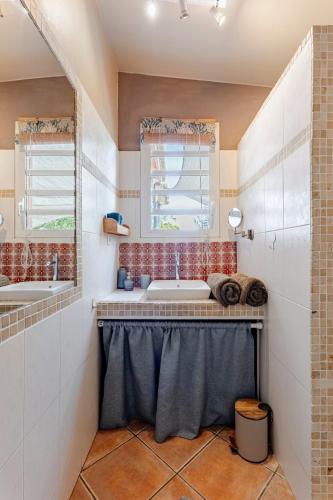 a bathroom with two sinks and a window at KAZUBUNTU in Saint-Leu