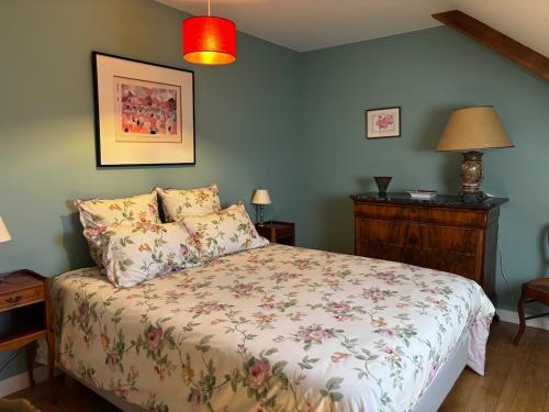 a bedroom with a bed with a floral bedspread at Maison familiale 10 pers à St Setiers in Saint-Setiers