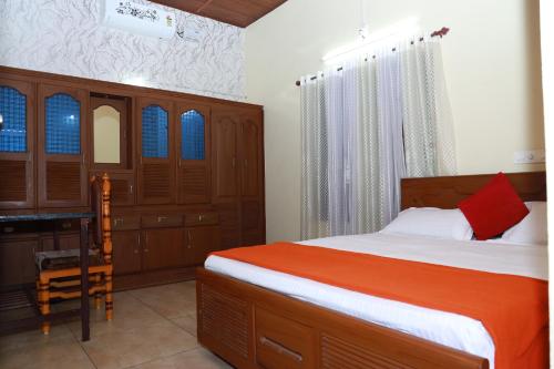 a bedroom with a bed and a desk in it at CITADEL HOLIDAY HOME in Vythiri