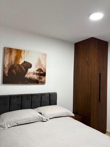 a bedroom with a painting of a bear on the wall at Monte Bravo Lodge in Yopal