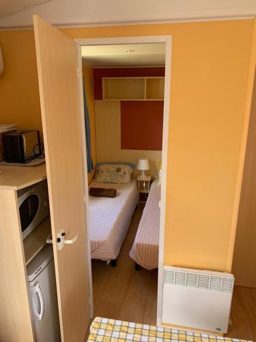 a small bedroom with two beds and a door open at Vickys Walls Bungalow in Pataias