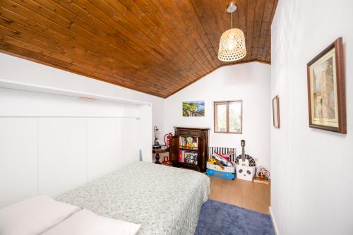 a bedroom with a bed and a wooden ceiling at Taloca Do Grilo in Baião