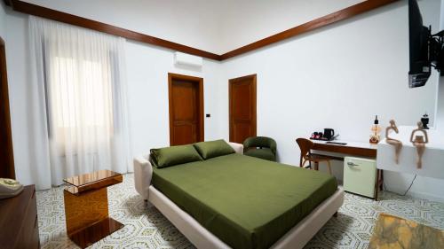 a bedroom with a green bed and a desk at The Suite - Trani centro in Trani
