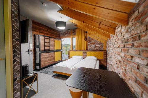 a bedroom with two beds and a brick wall at Apartamenty Wieliczka in Wieliczka