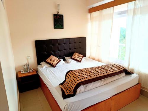 a bedroom with a large bed with a black headboard at CLOUDS Hotel and restaurant in Gangtok