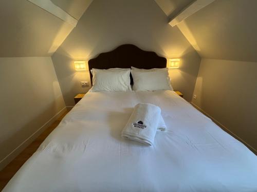 a bed with a white towel on top of it at Charmante Maison avec Jardin Privé - PACY SUR EURE in Pacy-sur-Eure