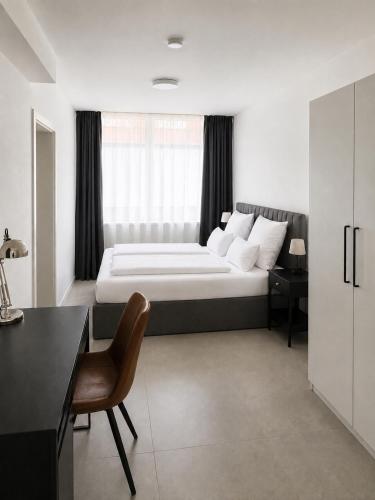 a bedroom with a bed with a desk and a chair at Boutique Hotel Celler Altstadt - 24h Check-in in Celle
