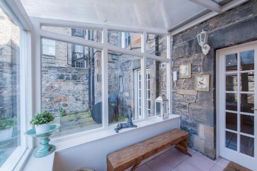 a window with a bench in a room with a stone wall at Apartment Jamaica Street 7 in Edinburgh