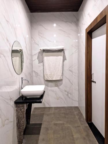 a bathroom with a sink and a mirror at Hotel Keshar Palace Shani Shingnapur in Sonai