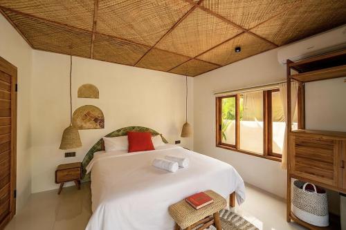 a bedroom with a white bed and a window at 2BR, Private Pool, Prime Location, Tropikarma in Toyapakeh