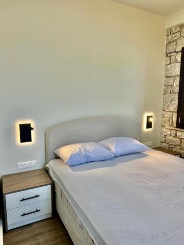 a bedroom with two beds and a brick wall at Thelea Mani in Kafióna