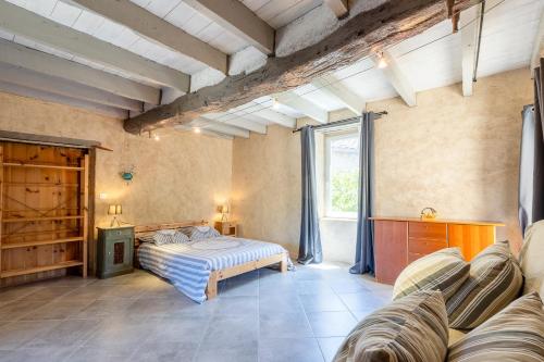 a bedroom with a bed and a couch at Maison de Charme en Pleine Nature in Bournazel