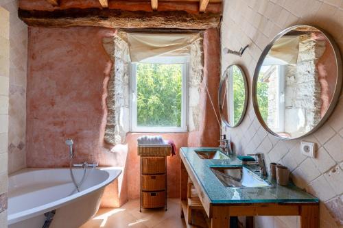 a bathroom with a tub and a sink and mirror at Maison de Charme en Pleine Nature in Bournazel