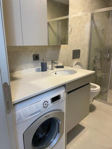 a bathroom with a washing machine and a sink at Oksijen in Urla