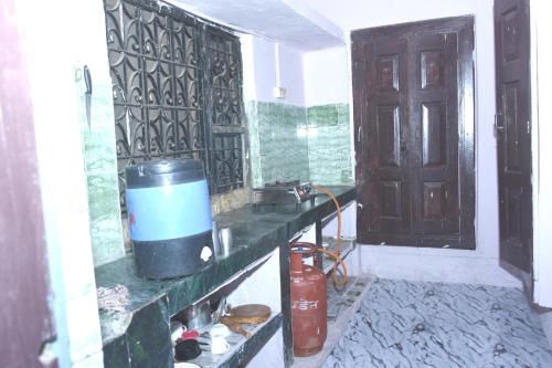 a kitchen with a counter with a bucket on the wall at Shukla home stay in Jabalpur