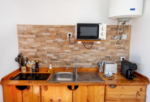 a kitchen with a sink and a tv on the wall at VILA NATURA in Barreiro