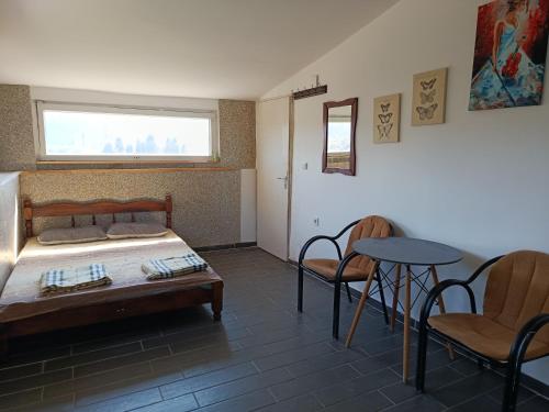 a bedroom with a bed and two chairs and a table at Solara in Bar