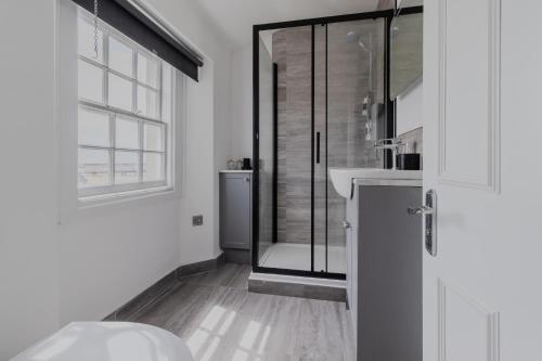 a white bathroom with a shower and a sink at Executive 2BR Business & Contractor Stay in Weston-super-Mare