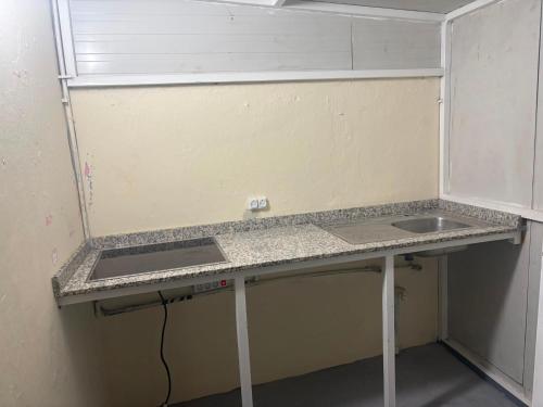a kitchen counter with a sink in a room at casa celia in Asilah