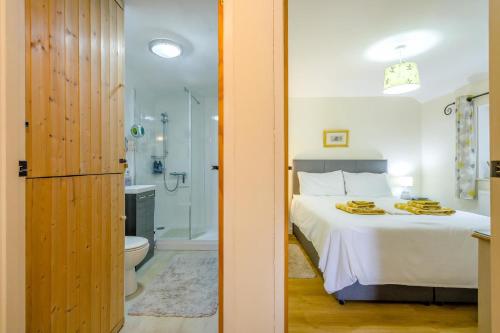 a bedroom with a bed and a bathroom with a shower at 1 Bed in Snape oc-9tts in Snape