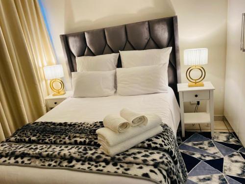 ein Schlafzimmer mit einem großen Bett, auf dem Handtücher liegen in der Unterkunft Comfy Nest Guest House in Durban