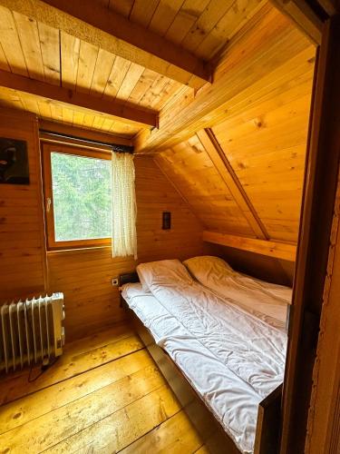 a bedroom in a log cabin with a bed in it at VILA PAVLOVIC in Kopaonik