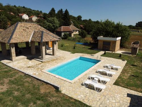 an overhead view of a pool with chairs and a gazebo at Čajića avlija pool house in Obrenovac