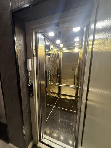 a glass door of a elevator in a room at Irmouli in Sétif