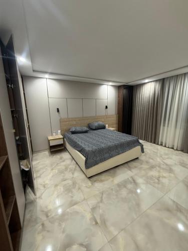 a bedroom with a bed and a marble floor at Irmouli in Sétif