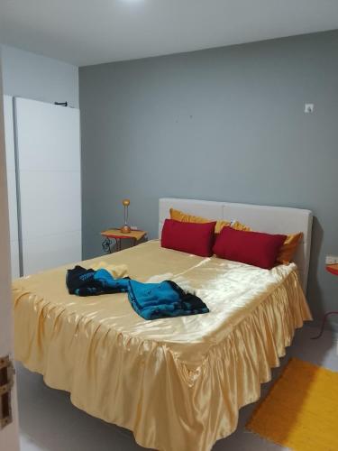 a bedroom with a large bed with red pillows at Rent Vacancy Arcoiris in Tías