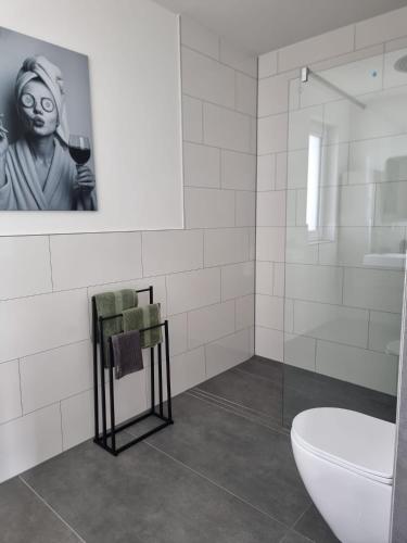 a bathroom with a toilet and a picture of a woman at Apartment Affengrün in Weyhausen
