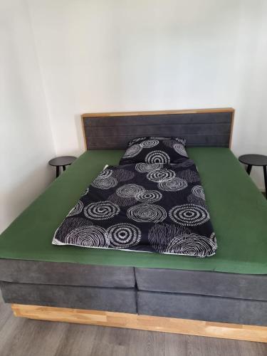 a bed with a black and white bedspread on it at Apartment Affengrün in Weyhausen