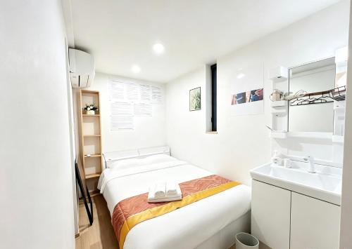 a small white room with a bed and a sink at Hananosato 池袋本店 池袋駅から近く 新宿渋谷銀座へ移動しやすい 周辺に 24 時間コンビニ 昔ながらの銭湯があり 人気の漫画本店も徒歩圏内 多様なタイプの客室を取り揃え 東京観光 都市散策 ショッピングにおすすめ in Tokyo