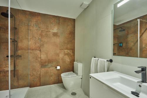 a bathroom with a toilet and a sink and a shower at Silken Atlantis Playa - Holiday Homes in Las Palmas de Gran Canaria