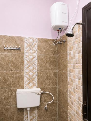 a bathroom with a toilet and a water tank at The grand chateau in Singapperumālkovil