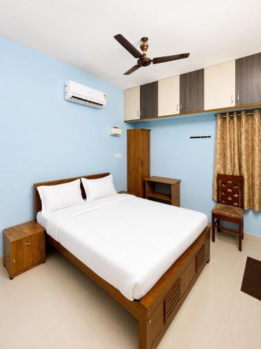 a bedroom with a bed with a ceiling fan at The grand chateau in Singapperumālkovil