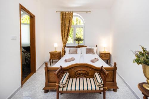 a bedroom with a large wooden bed and a window at Jákób-Vár Vendégház in Füzér