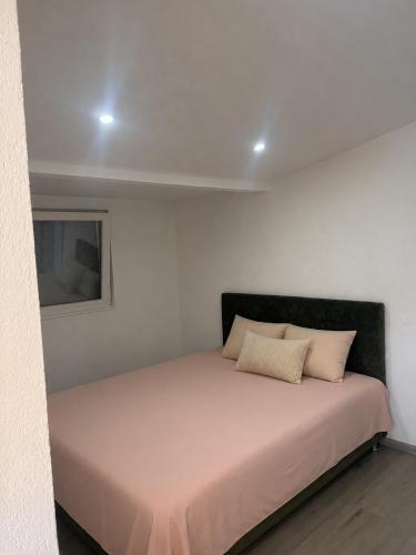 a bed in a white room with two pillows on it at Villa Eden Prijecani in Banja Luka