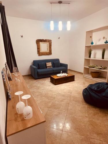 a living room with a blue couch and a table at Sicilia Vacation rooms in Trapani