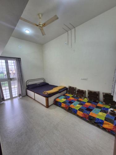 two beds in a room with a ceiling at Todkars Villa in Kolhapur