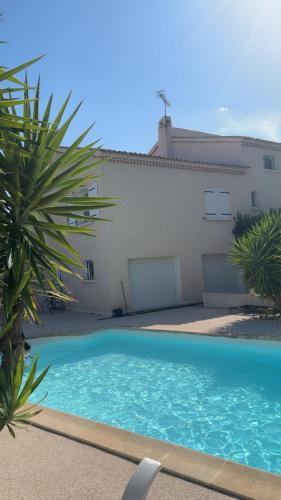 a swimming pool in front of a house at Azure Pool Villa in Marseille