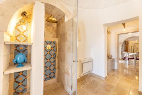 a room with a shower and a tile wall at Villa Trulli del Gelso in Carovigno