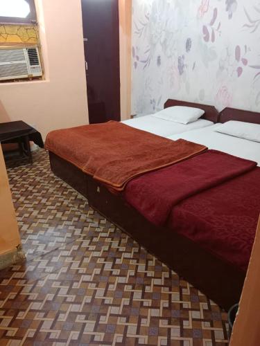 a bedroom with two beds with a red blanket on them at Hotel Raj Bed And Breakfast in Agra