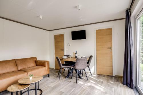 a living room with a couch and a table at Cube I stijlvol en licht 4 persoons chalet in Zennewijnen