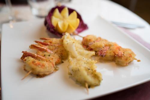a white plate with some food on a table at Hotel Ascot & Spa in Rimini