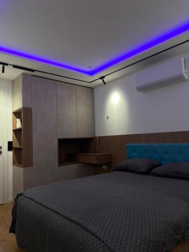 a bedroom with a bed with a purple lighting at Ines Apartment in Sarajevo
