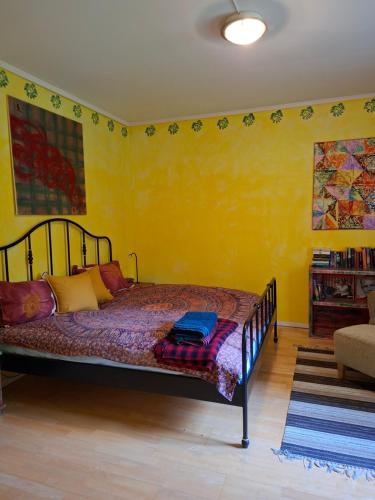 a bedroom with a bed in a yellow wall at Ferienwohnung Käthe in Filipstad