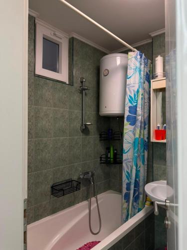 a bathroom with a bath tub and a sink at Ines Apartment in Sarajevo