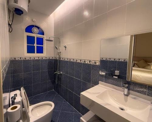 a bathroom with a sink and a toilet and a mirror at أجنحة كتارا صلالة Katara Suites Salalah in Salalah