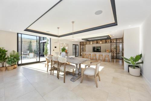a dining room and kitchen with a table and chairs at Designer Haus - Pool - Sea Views - 7BR - Sleeps 14 in Brighton & Hove